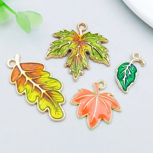 Vue macro de breloques feuilles d'érable en émail coloré pour la création de bijoux