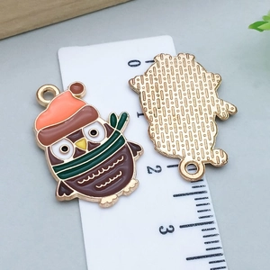 Détail des breloques hibou en émail avec mesure de 2,6 cm sur règle pour bijoux DIY