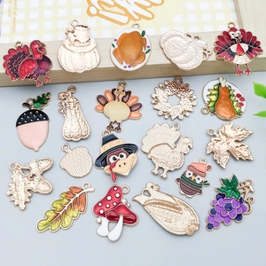 Détail macro de breloques émaillées dinde et feuille d'érable pour création de bijoux DIY