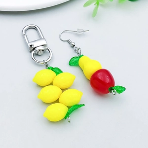 Detail of colorful acrylic fruit pendants featuring lemon keychain and apple earrings