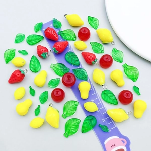 DIY mixed acrylic fruit pendants like strawberry and lemon with metal rings on scale