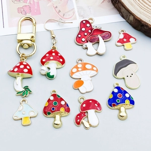 Detalle de colgantes de setas coloridas de aleación esmaltada para joyería artesanal