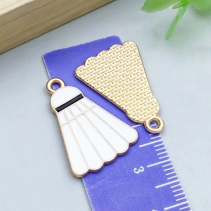 Macro view of badminton shuttlecock charms showing size scale and gold plating details