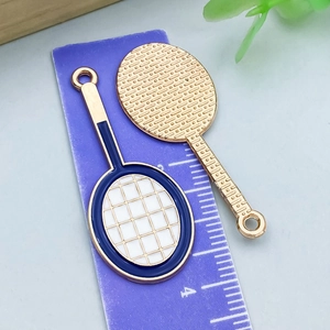 Macro detail of tennis racket pendant charm with blue enamel and gold finish, 40mm size