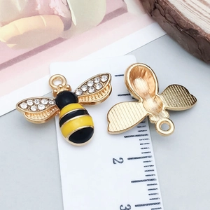 Makroaufnahme von Emaille-Bienenanhängern mit Strasssteinen für DIY-Schmuckzubehör