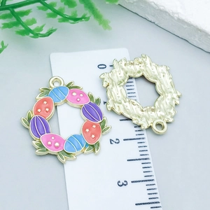 Detail view of colorful enamel Easter wreath pendants with eggs on a scale measuring card