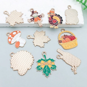 Detail of colorful enamel Thanksgiving charms featuring turkeys and maple leaves