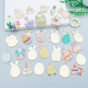 Flat lay of colorful enamel Easter charms with rabbits and eggs on blue background