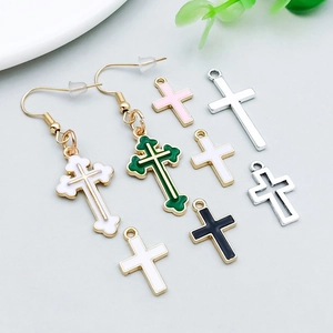 Detailopname van kleurrijke emaille en zilveren kruisbedeltjes voor DIY sieraden maken