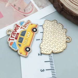 Détail du pendentif taxi en émail jaune avec texte Travel Time et dos en métal maillé