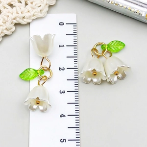 Detailed view of lily of the valley acrylic flower pendant with ruler for size reference