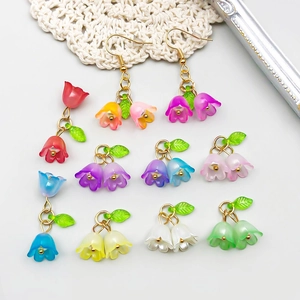 Colorful lily of the valley acrylic flower charms and earrings shown on a lace mat