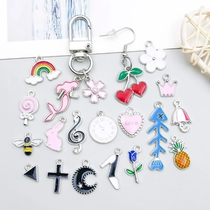 Detailed assortment of colorful enamel charms featuring animals and fruits for DIY jewelry