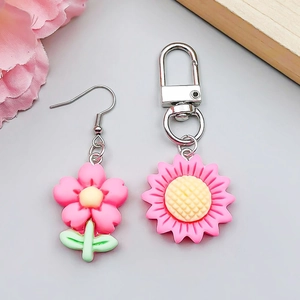 Detail of pink resin tulip and sunflower charms with metal clasp and green stems
