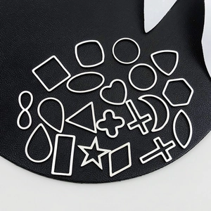 Macro shot of 20 assorted stainless steel hollow geometric frames on black leather base
