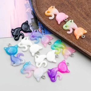 Close-up of colorful glitter resin cat pendants for DIY jewelry with metal rings