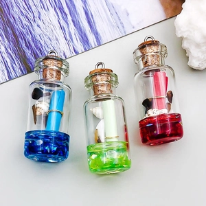 Détail de breloques bouteilles à vœux colorées avec coquillages et anneaux pour bijoux DIY