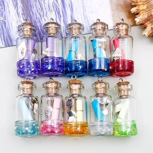 Gros plan de mini bouteilles de vœux en verre coloré avec coquillages pour bijoux DIY