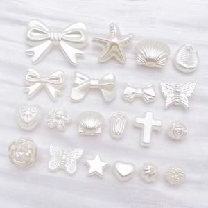 Vue macro des breloques en ABS blanc perle en forme de papillon pour bijoux DIY