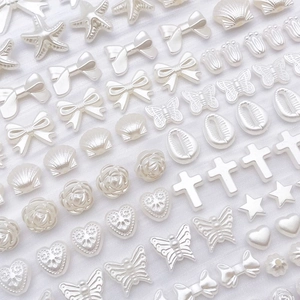 Vue détaillée de breloques en perles ABS blanc crème en formes de papillon et d'étoile