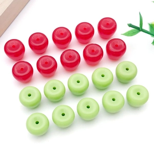 Detalle de dijes de manzana en acrílico rojo y verde con orificio central para joyería