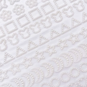 Vista macro de pegatinas de perlas acrílicas blancas en forma de estrella y luna para DIY