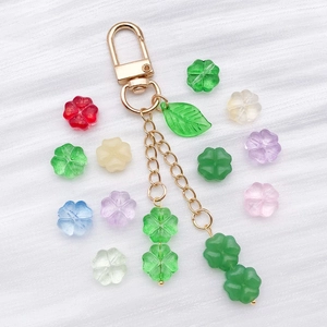 Macro detail of colorful transparent glass four-leaf clover beads and clover keychain accessory