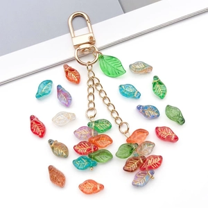Nahaufnahme von bunten Glasperlen in Blattform mit goldenen Adern für DIY-Schmuck