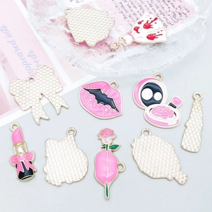 Detailed close-up of mixed enamel alloy charms in pink and gold for DIY jewelry making