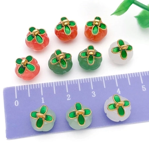 Colorful glass pumpkin pendants with gold leaf hooks and ruler for size scale reference