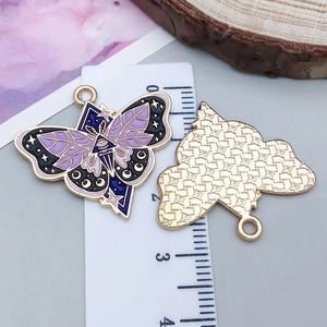 Detail van de vlinder hanger met emaille symbolen en liniaal die 35mm breedte toont