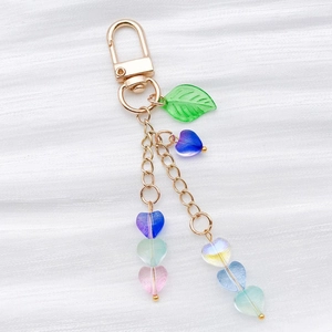 Detail of colorful translucent heart-shaped glass beads and gold lobster clasp pendant
