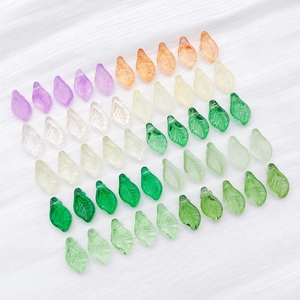 Close-up of mini glass leaf charms with leaf vein details for DIY jewelry making
