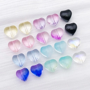 Macro view of colorful heart-shaped glass beads with vertical holes for DIY jewelry