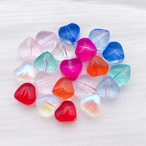 Gros plan de perles en verre coloré en forme de cœur pour la création de bijoux