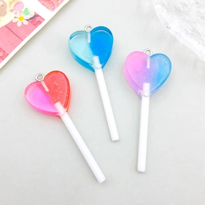 Macro shot of glitter resin heart lollipop charms with metal loops in assorted colors