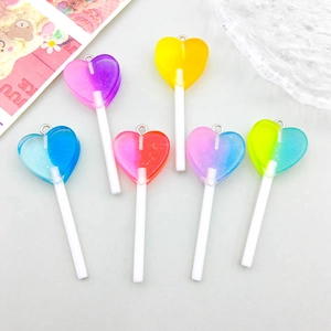 Macro shot of colorful resin heart lollipop pendants with glitter for DIY jewelry making