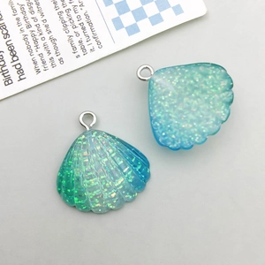Detailed macro view of two blue glitter resin seashell pendants with silver metal rings