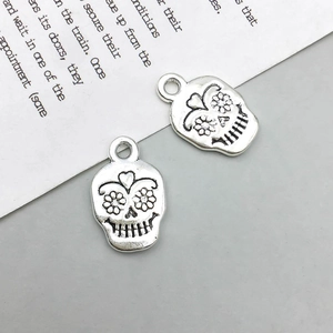 Detailaufnahme von Vintage-Silber-Totenkopfanhängern mit Blumenmuster für DIY-Schmuck