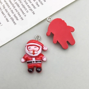 Dettaglio del ciondolo Babbo Natale con fronte colorato e retro in resina rossa con gancio