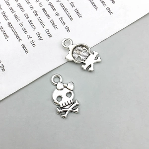 Makroaufnahme von Vintage-Silber-Totenkopfanhängern mit Schleife für DIY-Schmuckprojekte