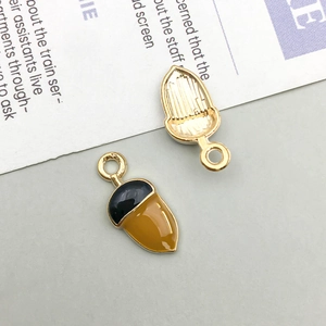 Front and back view of cartoon acorn pendant showing gold plating and textured metal