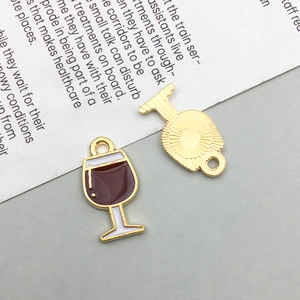 Detail of red wine glass charm showing red enamel front and golden textured back