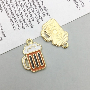 Detail of cartoon beer mug charms with light gold plating and radial sunburst texture