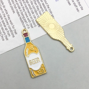 Detailed view of beer bottle alloy charms showing yellow enamel front and golden sunburst back