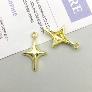Detail of two hollow gold four-point star alloy pendants for DIY jewelry making
