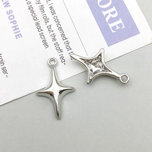 Close-up of silver-tone hollow four-pointed star metal charms for DIY jewelry making