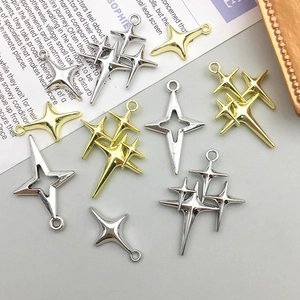 Mix of gold and silver hollow star charms for DIY jewelry making on a magazine backdrop