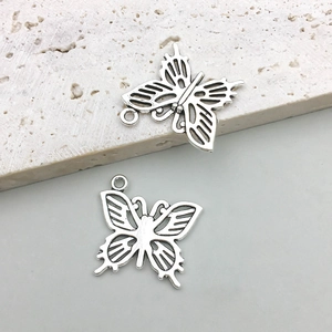 Macro detail of retro silver hollow butterfly charms for DIY jewelry making