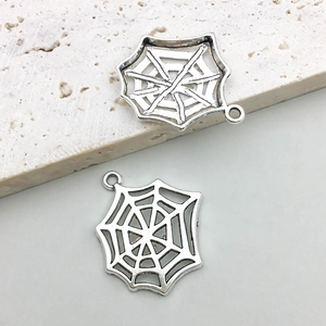 Close-up of silver spider web charms with detailed镂空work for DIY jewelry making